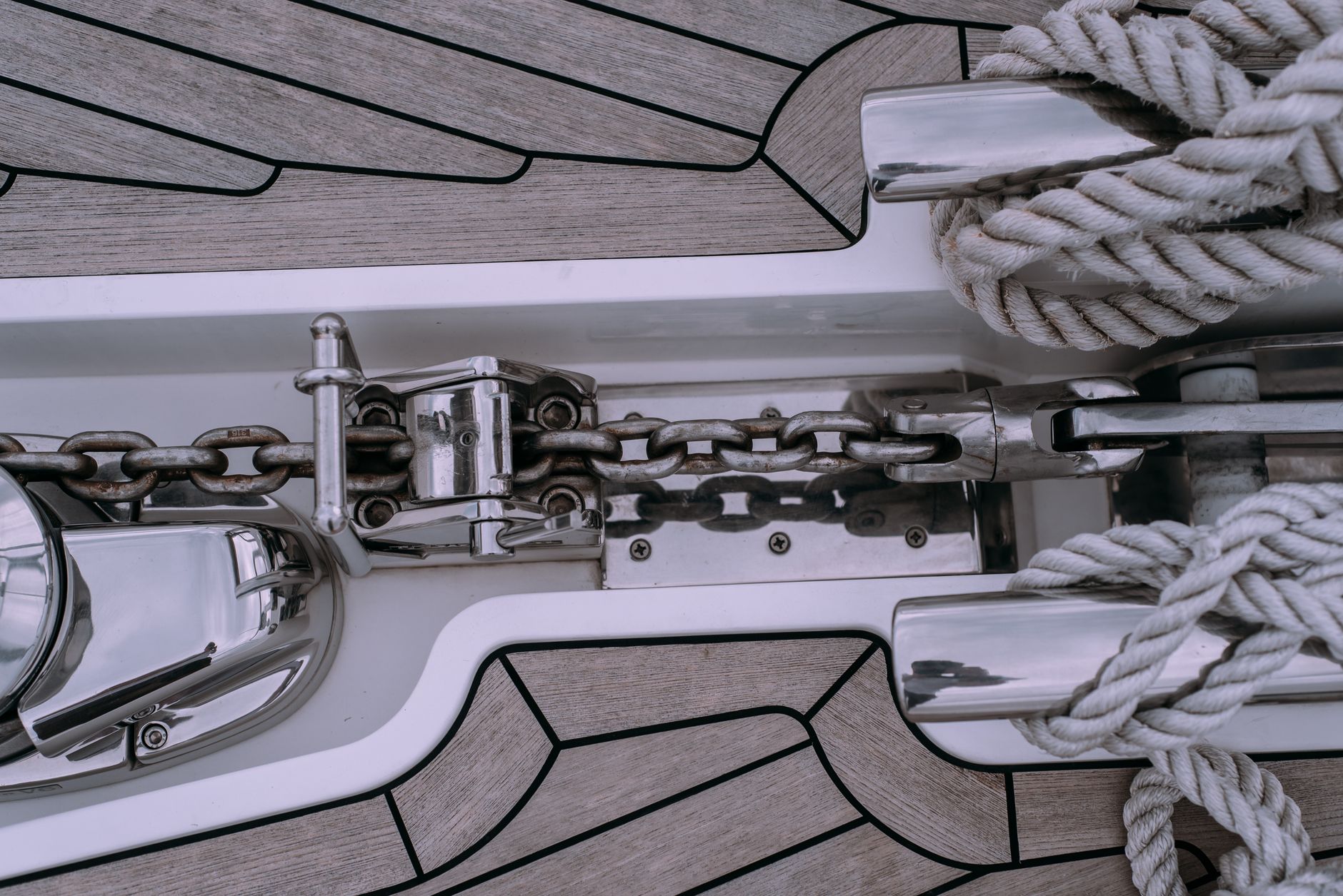 Detailed shot of sailboat deck featuring a chain and rope setup, ideal for marine themes.
