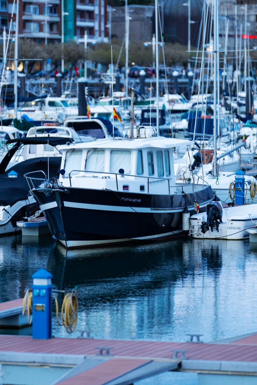 A vibrant scene at a marina with various boats moored, showcasing a peaceful waterfront atmosphere.